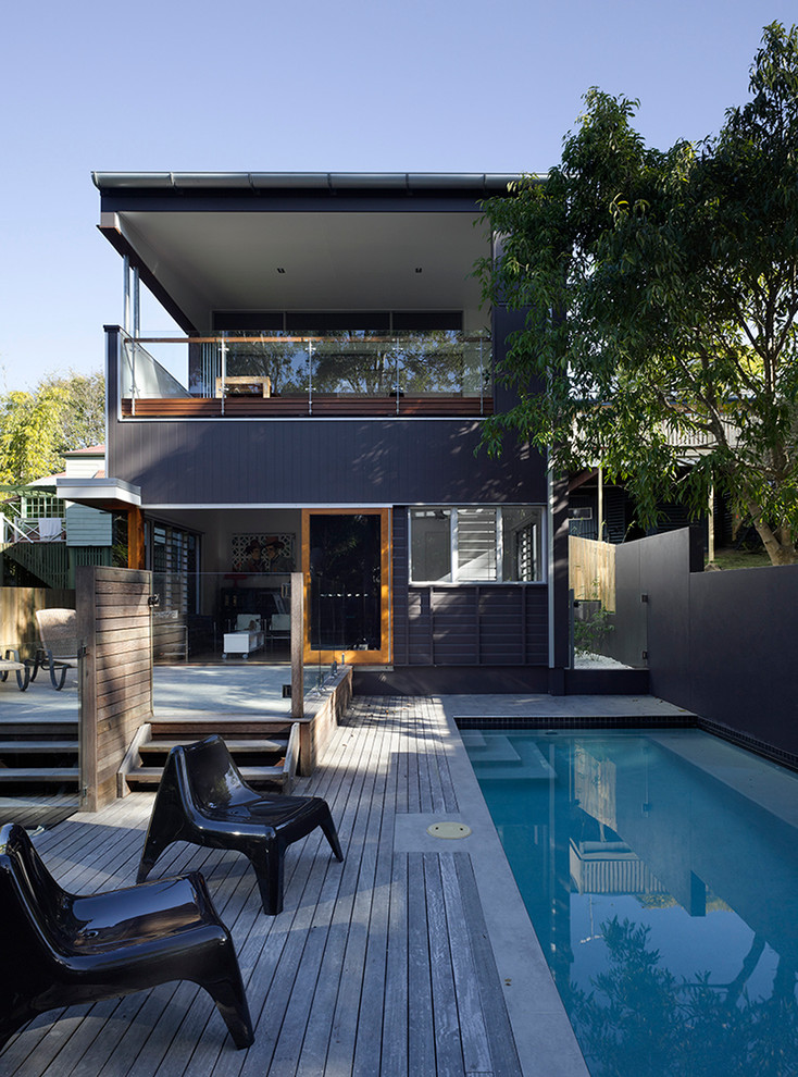 Idée de décoration pour un couloir de nage arrière design rectangle avec une terrasse en bois.