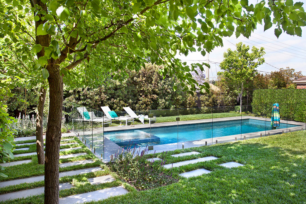 Foto de piscina actual de tamaño medio rectangular en patio trasero