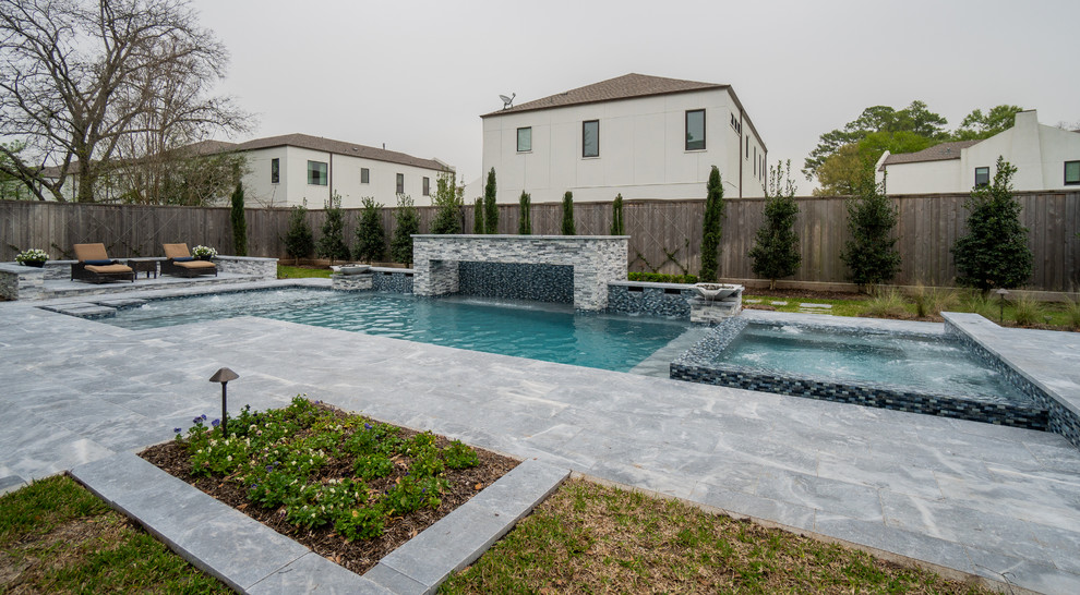 Cette photo montre une grande piscine arrière tendance rectangle avec des pavés en pierre naturelle.