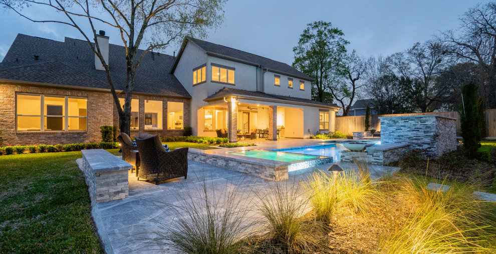 Großer Moderner Pool hinter dem Haus in rechteckiger Form mit Natursteinplatten in Houston