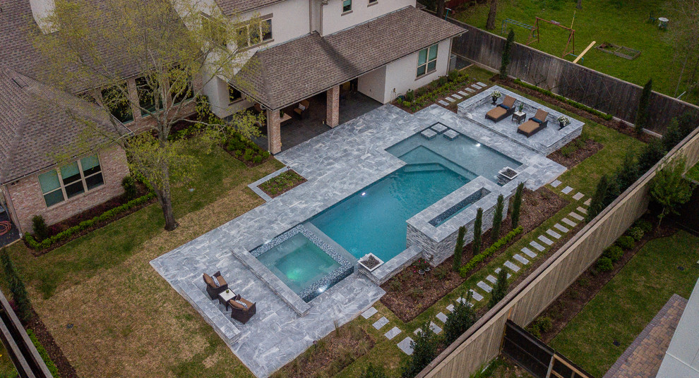 Imagen de piscina actual grande rectangular en patio trasero con adoquines de piedra natural