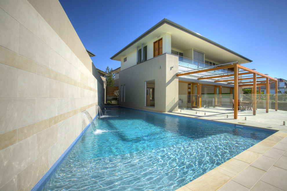 Exempel på en modern rektangulär pool längs med huset
