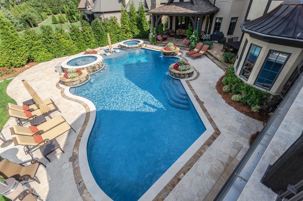 Foto di una grande piscina monocorsia minimal personalizzata dietro casa con una vasca idromassaggio e pavimentazioni in pietra naturale