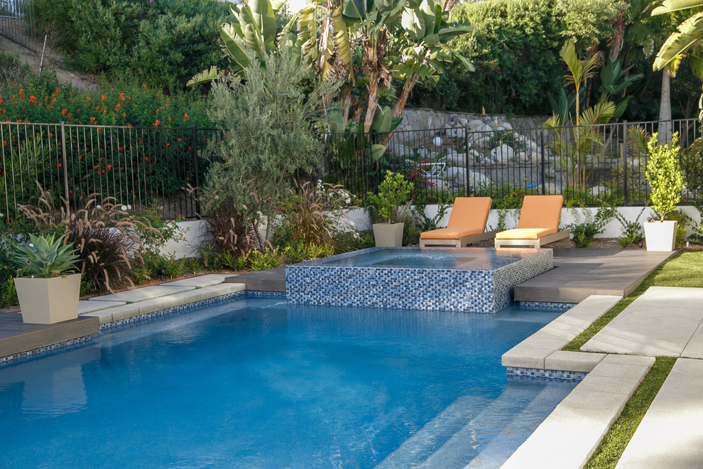 Medium sized contemporary back rectangular natural swimming pool in San Diego with a water feature and tiled flooring.