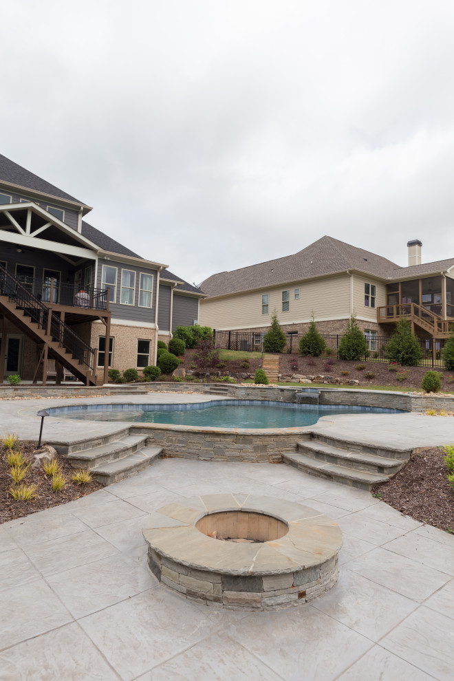 Imagen de piscinas y jacuzzis naturales clásicos de tamaño medio a medida en patio trasero con losas de hormigón