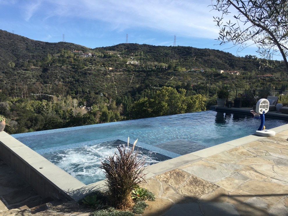 Inspiration for a mid-sized modern backyard tile and rectangular infinity pool remodel in Los Angeles