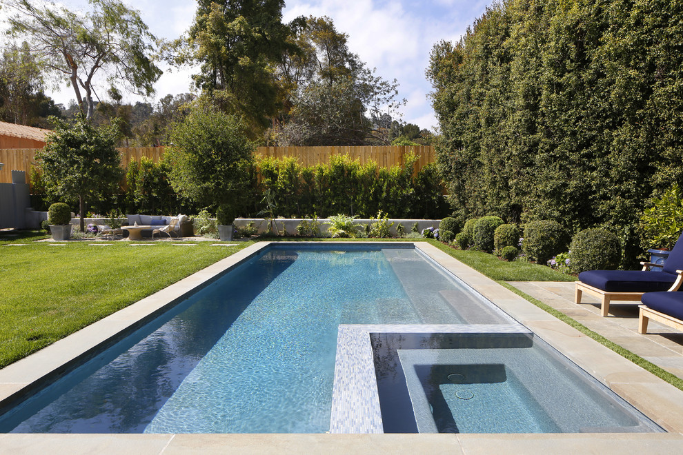 Foto di una grande piscina naturale chic rettangolare dietro casa con una vasca idromassaggio e piastrelle