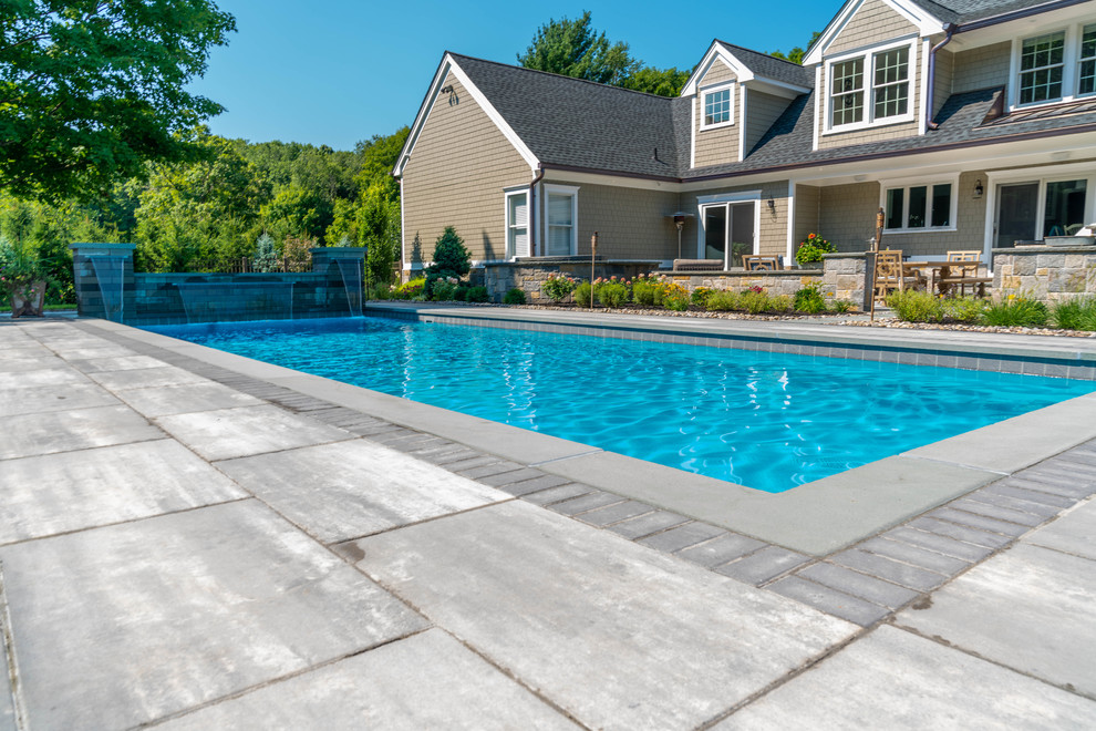 Esempio di una grande piscina moderna rettangolare dietro casa con pavimentazioni in cemento