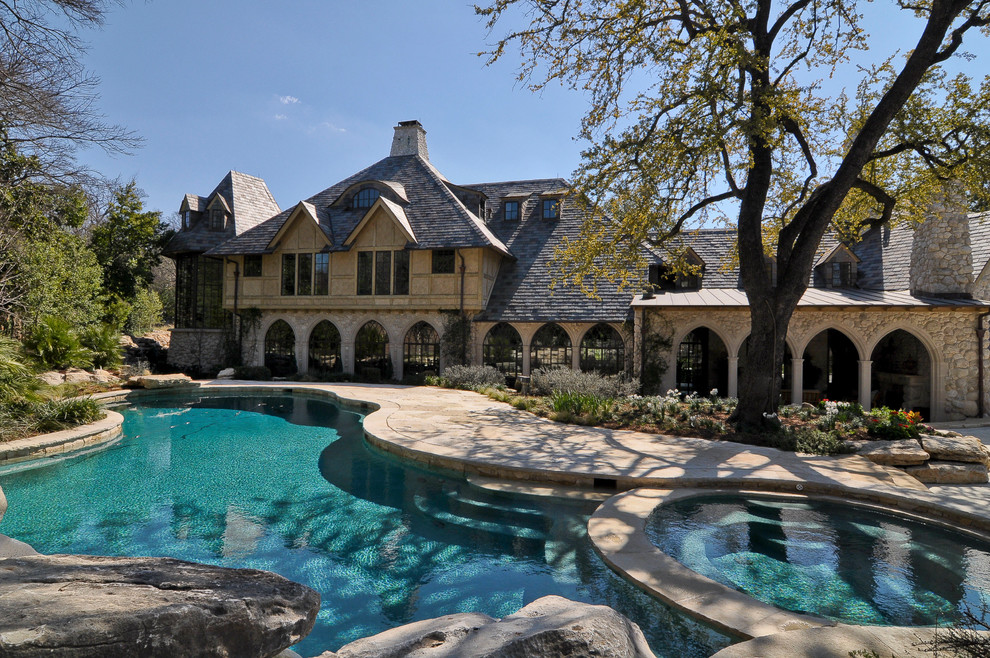 Immagine di una grande piscina classica dietro casa con una vasca idromassaggio