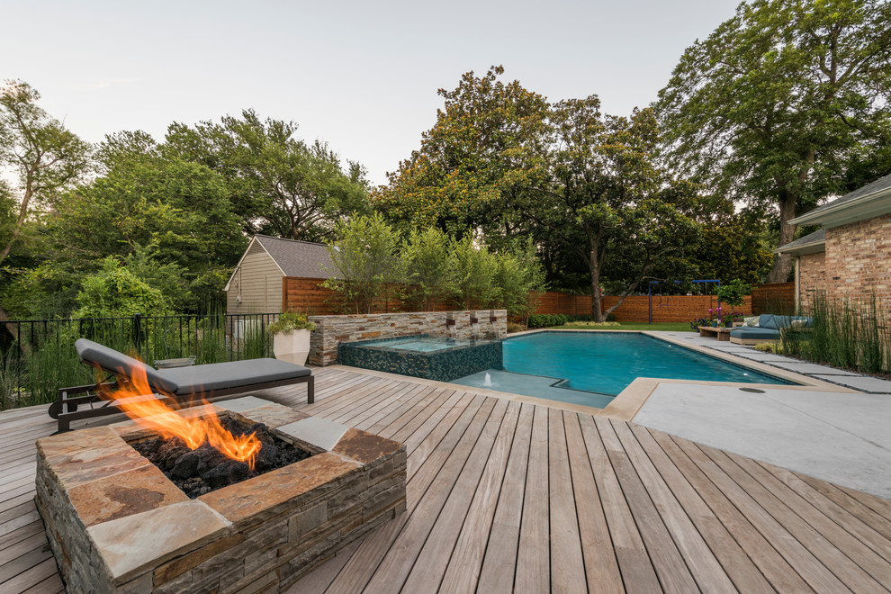 На фото: бассейн среднего размера, произвольной формы на заднем дворе в современном стиле с джакузи и покрытием из бетонных плит