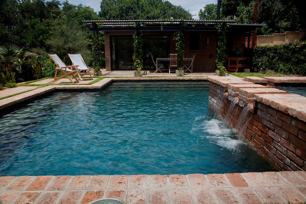 Modelo de piscinas y jacuzzis alargados clásicos pequeños a medida en patio trasero con adoquines de ladrillo