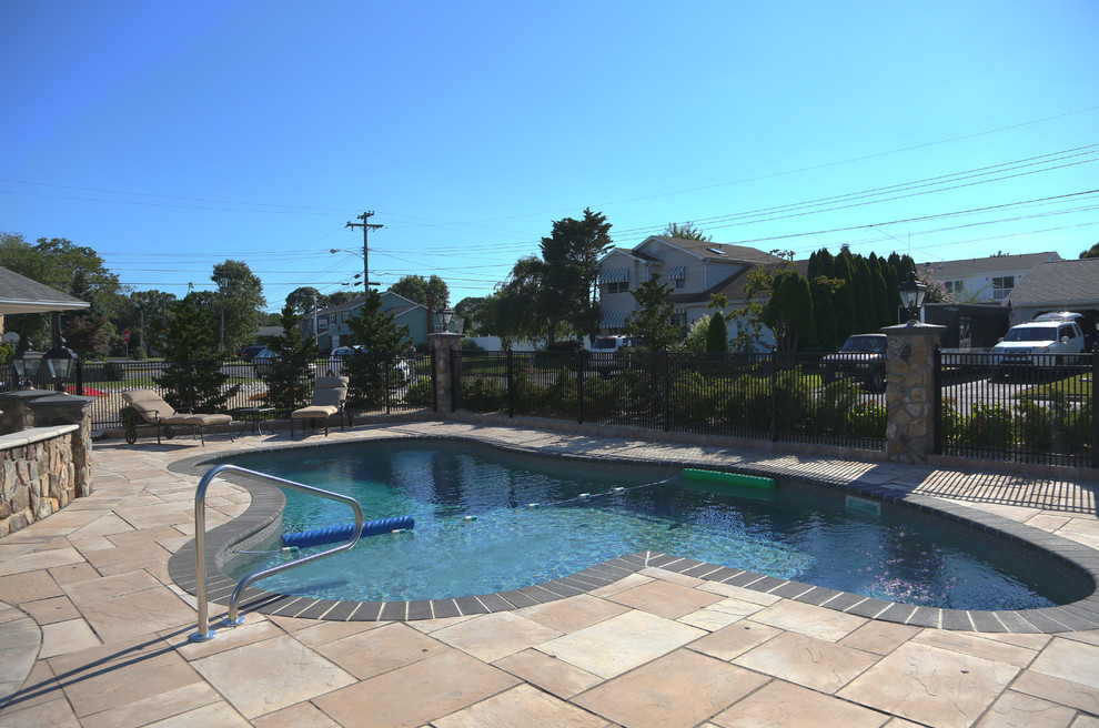Foto de piscina clásica grande a medida en patio lateral con adoquines de piedra natural