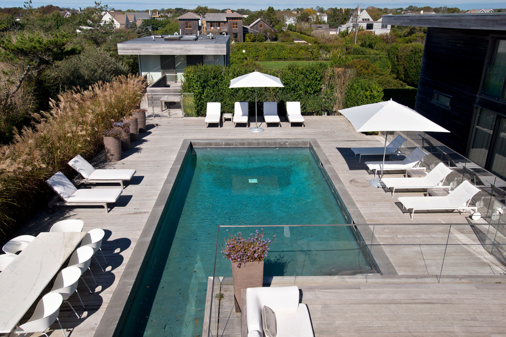 Aménagement d'une très grande piscine latérale moderne rectangle avec une terrasse en bois.