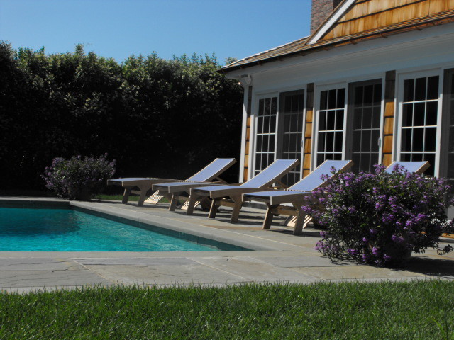 Cette photo montre une piscine arrière chic de taille moyenne et rectangle avec des pavés en pierre naturelle.