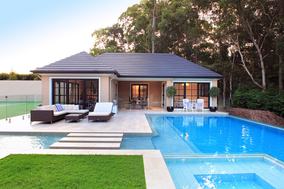 Design ideas for a large classic back custom shaped swimming pool in Brisbane with a pool house and tiled flooring.