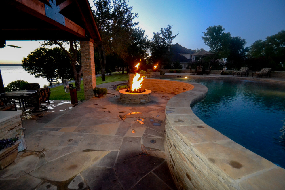 Ejemplo de piscina infinita rural grande a medida en patio trasero con adoquines de piedra natural