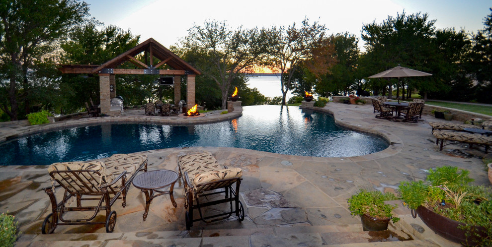 Pool - large rustic backyard stone and custom-shaped infinity pool idea in Dallas