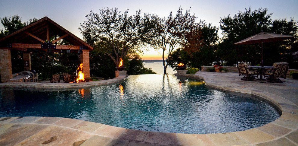 Example of a large mountain style backyard stone and custom-shaped infinity pool design in Dallas