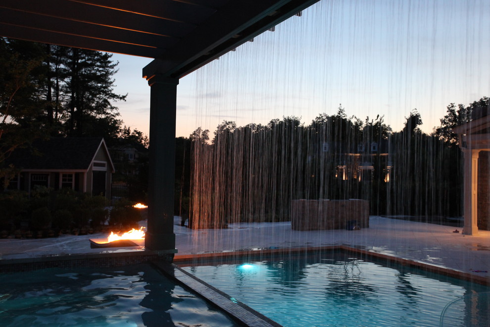 Esempio di una grande piscina monocorsia classica rettangolare dietro casa con una vasca idromassaggio e piastrelle