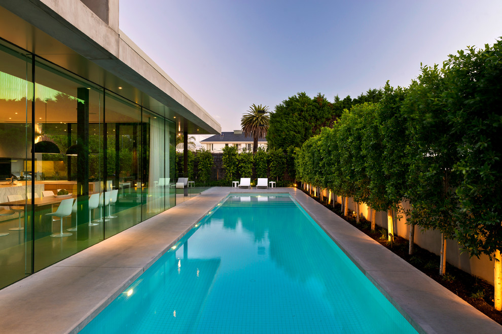 Imagen de piscinas y jacuzzis alargados minimalistas grandes rectangulares en patio trasero con losas de hormigón