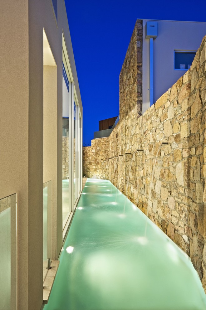 Foto di una piccola piscina monocorsia contemporanea personalizzata nel cortile laterale con pavimentazioni in pietra naturale