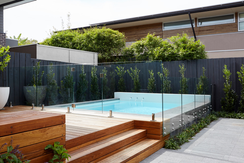 Réalisation d'une piscine hors-sol design rectangle avec une terrasse en bois.
