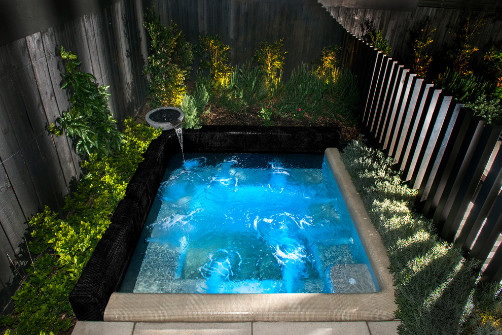 Cette photo montre une petite piscine arrière bord de mer sur mesure avec un bain bouillonnant et du carrelage.