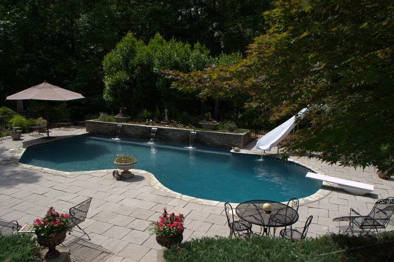 Foto di una grande piscina minimalista personalizzata dietro casa con fontane