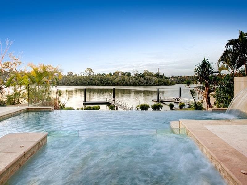 Modelo de piscina con fuente infinita moderna grande rectangular en patio trasero con adoquines de piedra natural