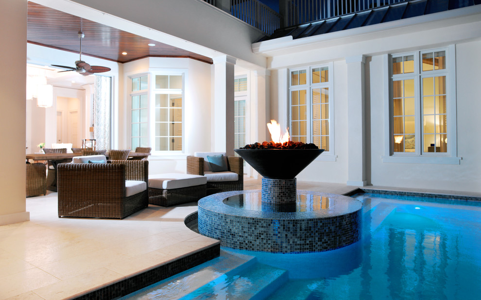 Esempio di un'ampia piscina monocorsia stile marinaro personalizzata dietro casa con una vasca idromassaggio e pavimentazioni in pietra naturale