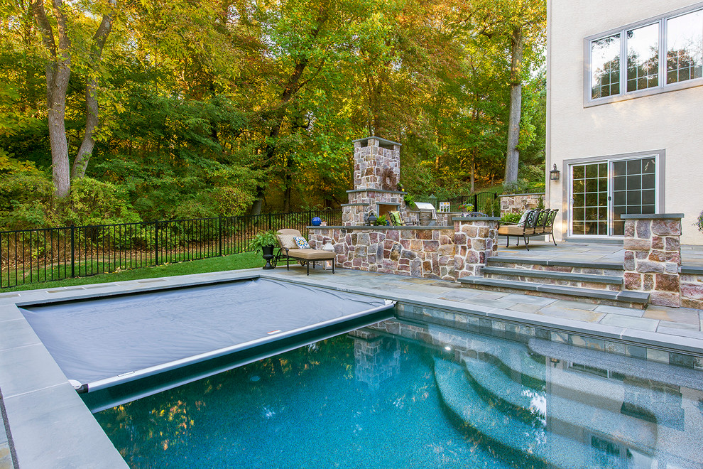 Foto di una piscina chic rettangolare di medie dimensioni e dietro casa con una vasca idromassaggio e pavimentazioni in pietra naturale