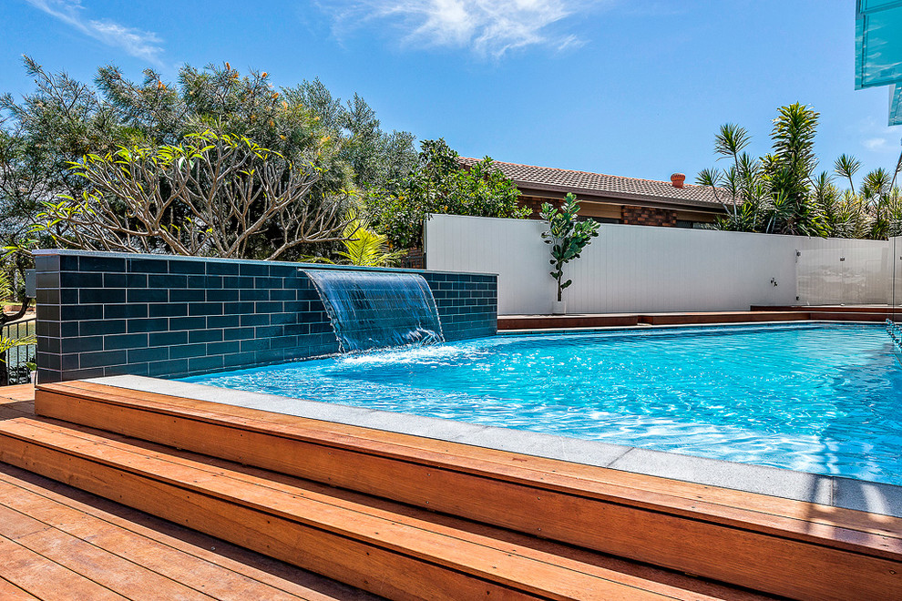 This is an example of a medium sized contemporary back custom shaped swimming pool in Brisbane with a water feature.