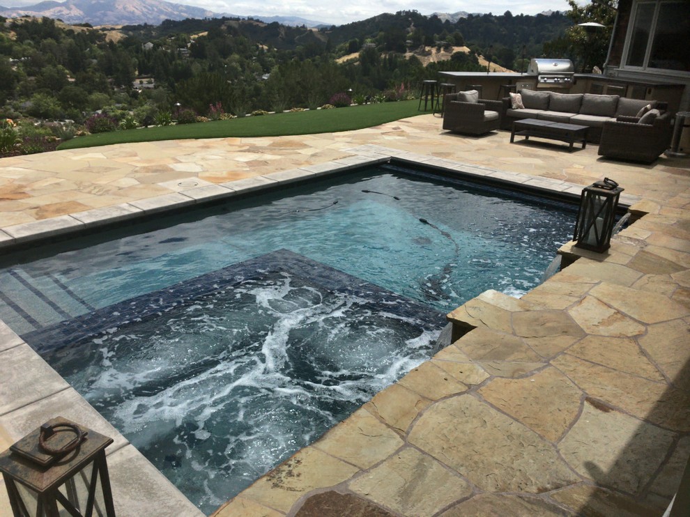 Inspiration for a large traditional back rectangular swimming pool in San Francisco with a water feature and natural stone paving.