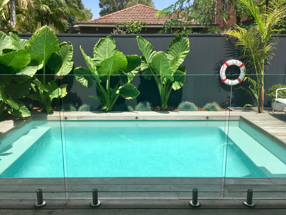 Medium sized nautical back rectangular natural swimming pool in Sydney with decking.