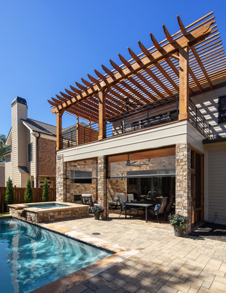 Esempio di una piscina naturale design rettangolare di medie dimensioni e dietro casa con una vasca idromassaggio e pavimentazioni in pietra naturale
