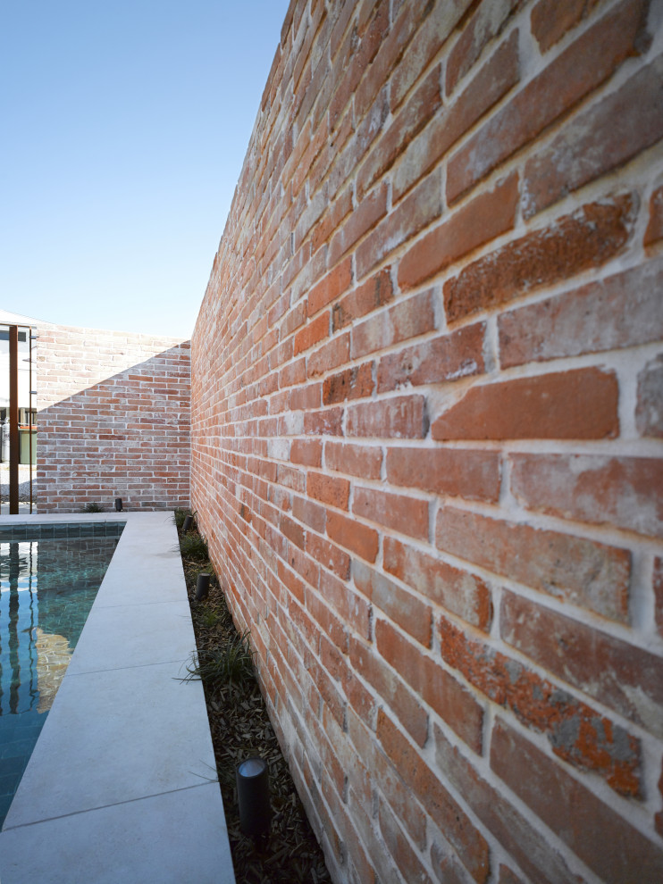 Cette photo montre une petite piscine hors-sol et arrière industrielle rectangle avec des solutions pour vis-à-vis et des pavés en pierre naturelle.