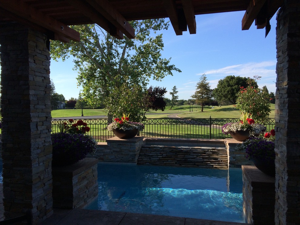 Ejemplo de piscinas y jacuzzis clásicos renovados grandes rectangulares en patio trasero con suelo de hormigón estampado