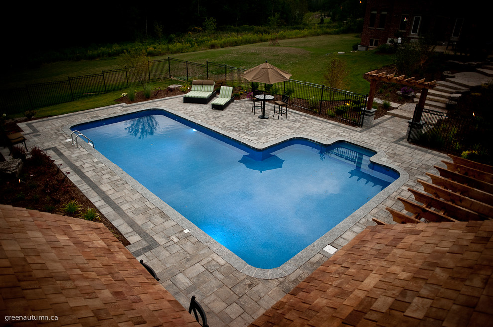Idee per una piscina naturale stile americano rettangolare di medie dimensioni e dietro casa con una dépendance a bordo piscina e pavimentazioni in cemento