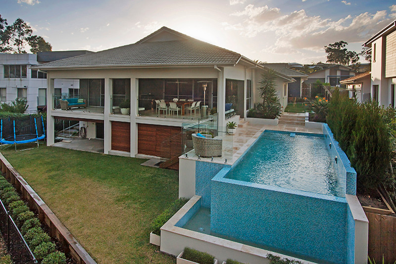 Foto di una piscina fuori terra contemporanea rettangolare di medie dimensioni e dietro casa con fontane e piastrelle