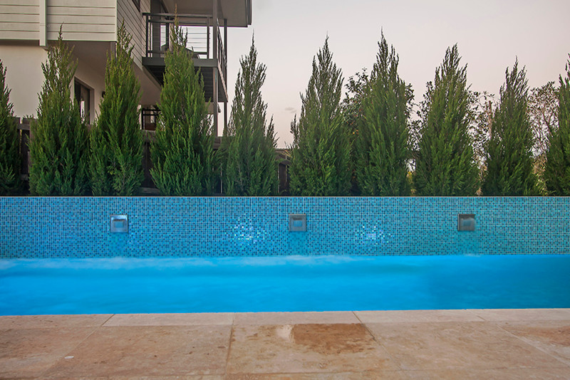 Cette photo montre une piscine hors-sol et arrière tendance de taille moyenne et rectangle avec un point d'eau et du carrelage.