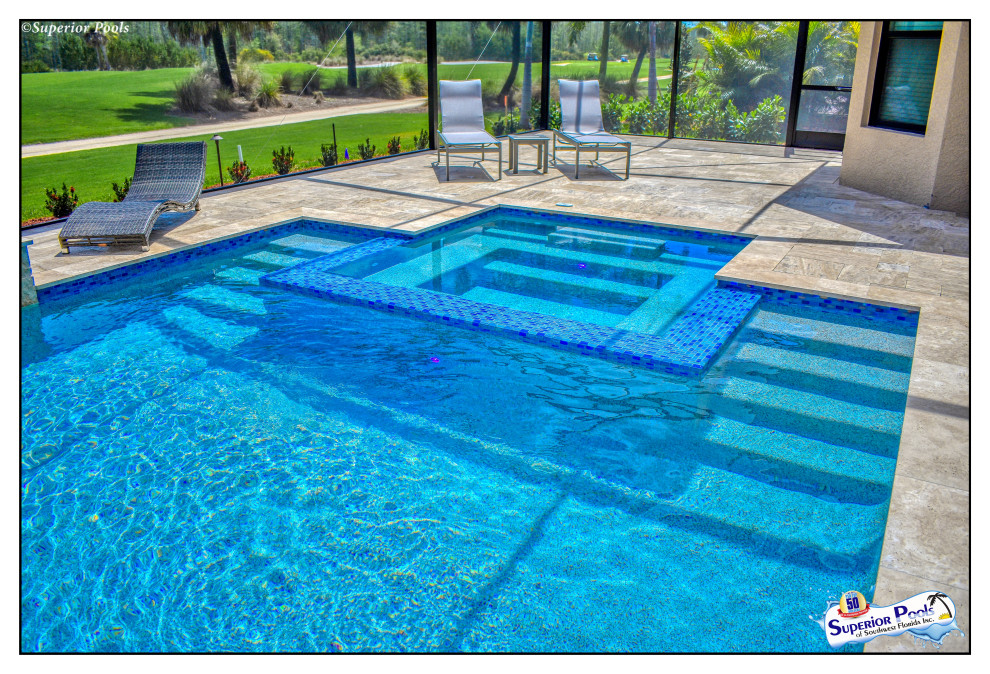 Imagen de piscina con fuente alargada exótica grande a medida en patio trasero con adoquines de piedra natural