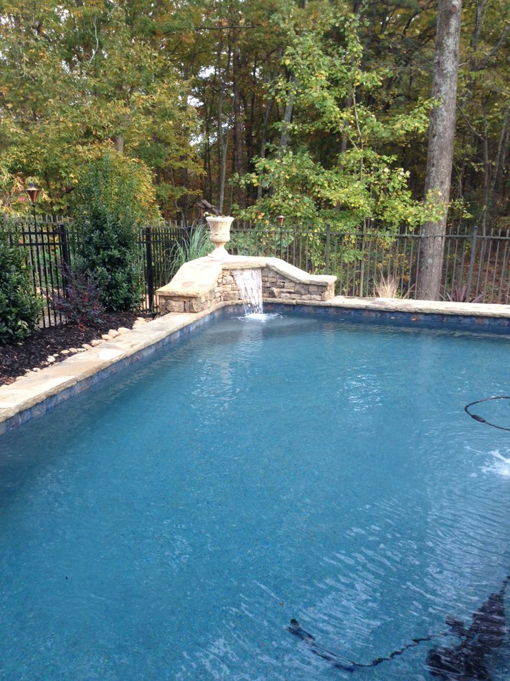 Diseño de piscina con fuente natural de estilo americano pequeña a medida en patio trasero con adoquines de piedra natural