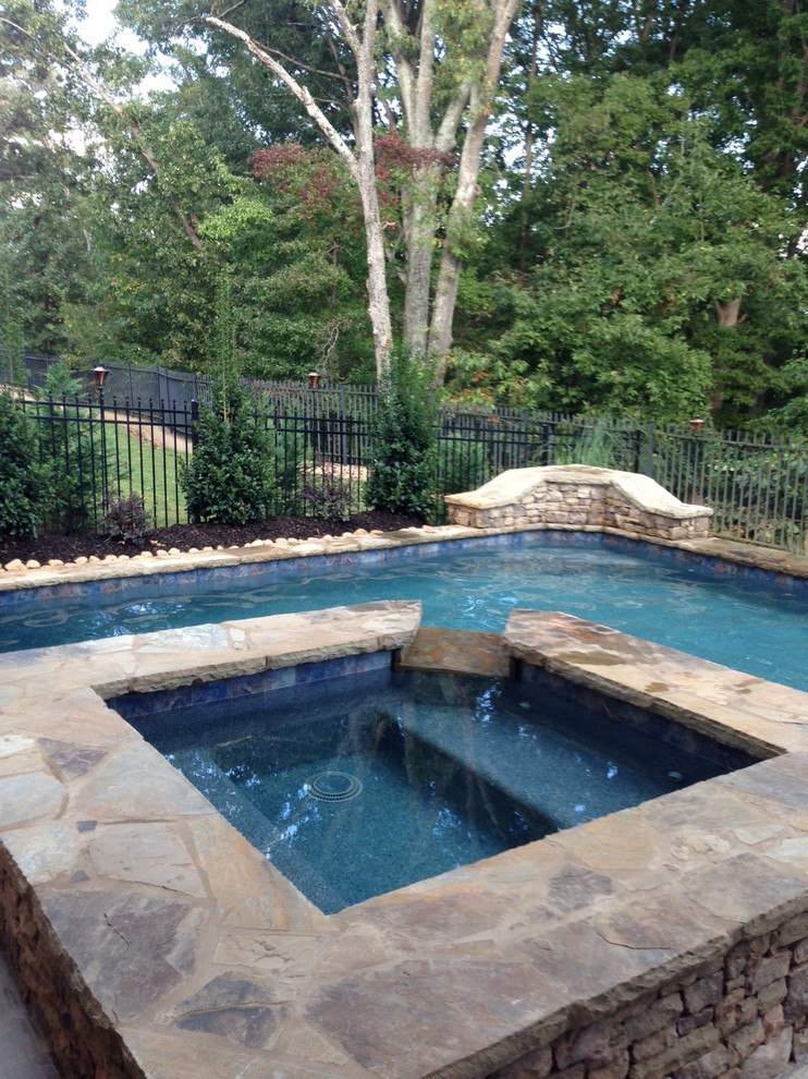 Exemple d'une petite piscine naturelle et arrière craftsman sur mesure avec un bain bouillonnant et une terrasse en bois.