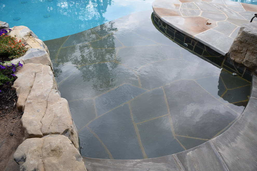 Diseño de piscina con fuente infinita minimalista de tamaño medio a medida en patio trasero con adoquines de piedra natural