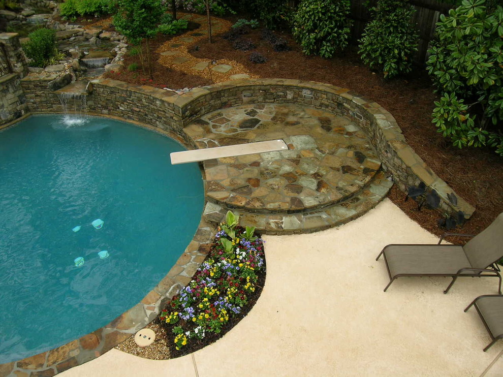 Пример оригинального дизайна: большой естественный бассейн произвольной формы на заднем дворе в классическом стиле с фонтаном и покрытием из каменной брусчатки