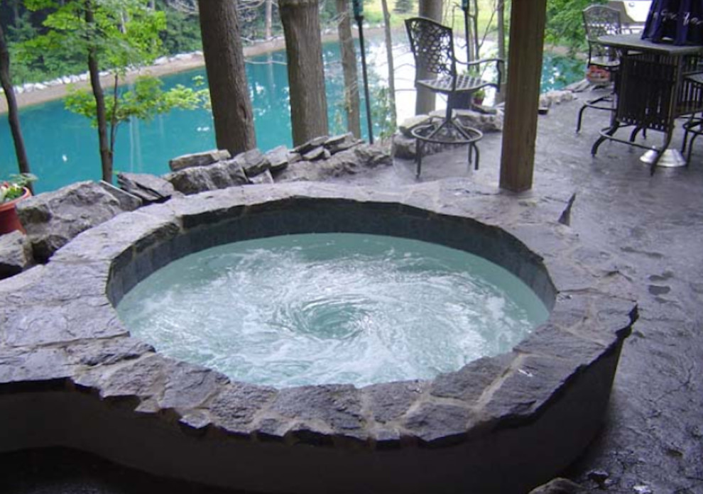 Imagen de piscinas y jacuzzis de tamaño medio redondeados con adoquines de piedra natural