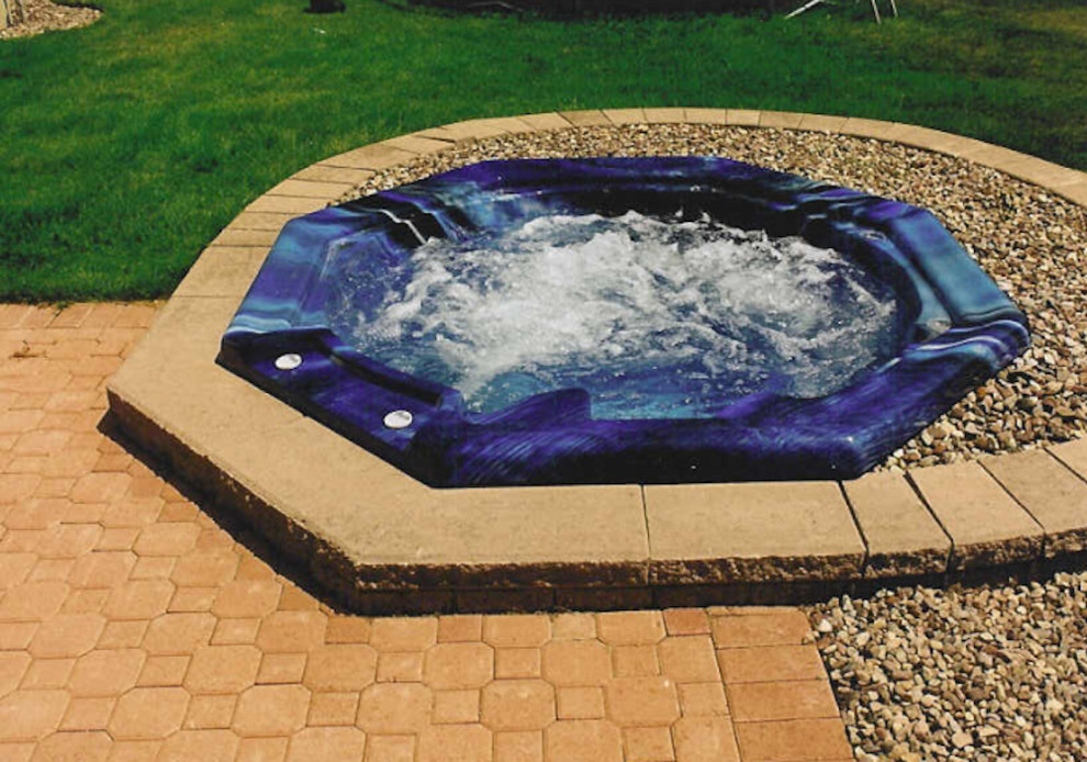 Immagine di una piccola piscina rotonda con una vasca idromassaggio e ghiaia