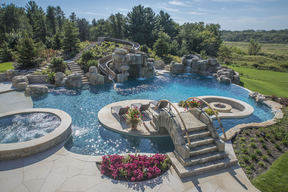 Ejemplo de piscinas y jacuzzis infinitos extra grandes a medida en patio trasero con adoquines de piedra natural