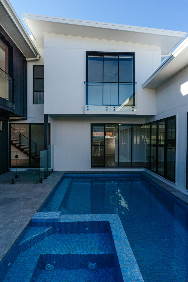 Foto de piscina de tamaño medio rectangular en patio con suelo de baldosas