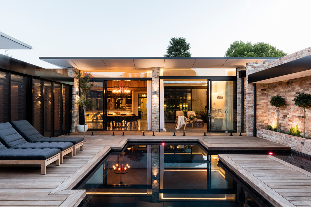 Inspiration pour une piscine design sur mesure avec une cour et une terrasse en bois.